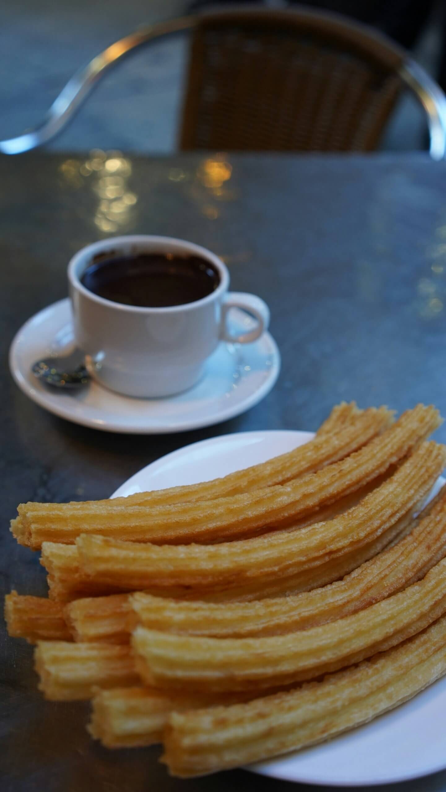 Plate of churros with thick chocolate sauce, a classic Spanish dessert enjoyed in Costa Blanca, Spain.