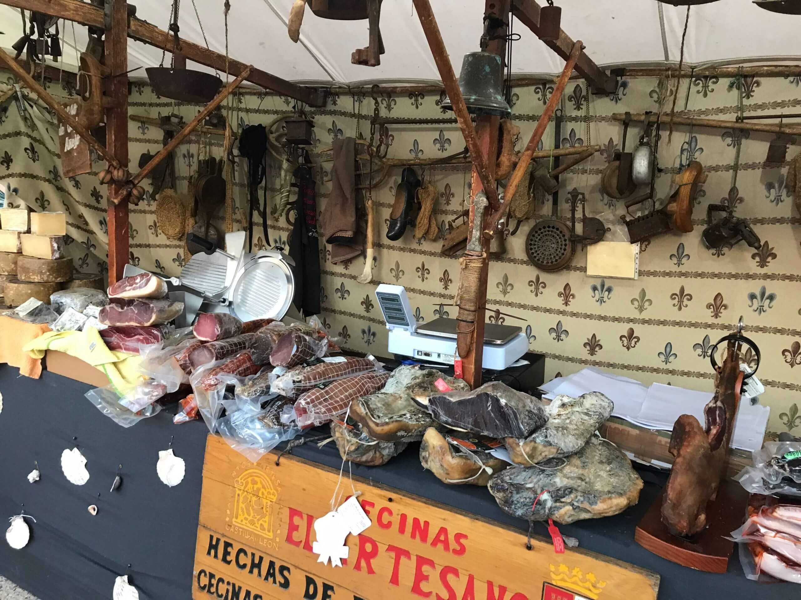 Traditional jamón ibérico legs hanging at a market stall in Costa Blanca, Spain.