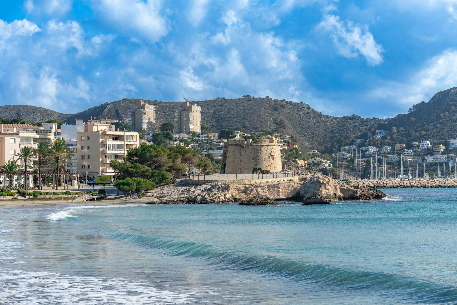 Scenic view of Moraira, Costa Blanca, with turquoise waters, sandy beaches, and Mediterranean townscape.