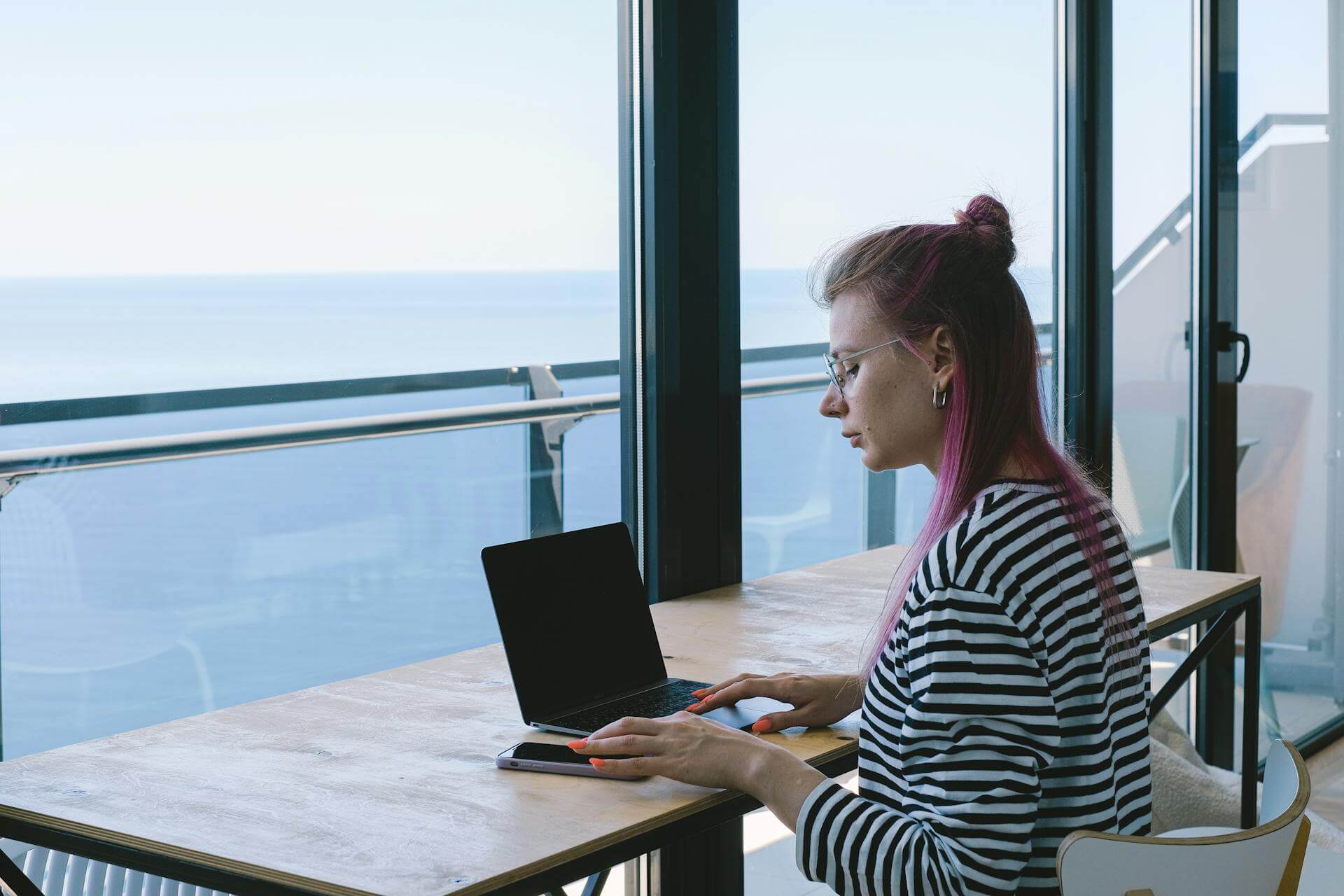 Digital nomad working on a laptop at a beach café in Alicante on Spain’s Costa Blanca.